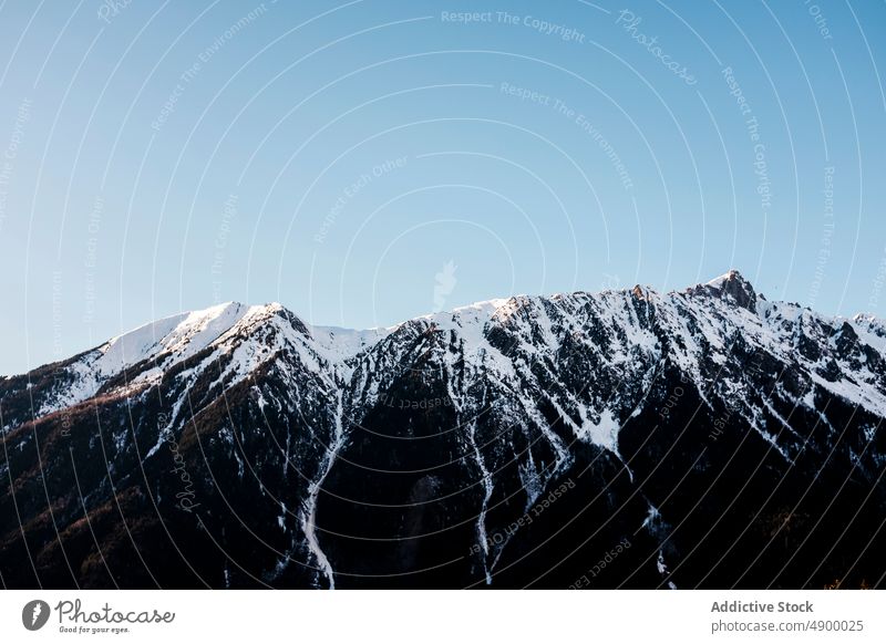 Snowy mountain peaks in highlands range snow winter rock nature hoarfrost cliff rime ridge weather cold blue sky climate environment rough formation slope