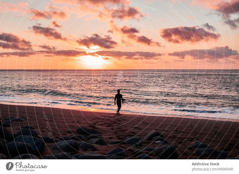 Unrecognizable traveler walking on beach at sunset tourism sundown sea water seashore nature adventure silhouette cloudy leisure rest journey recreation pastime