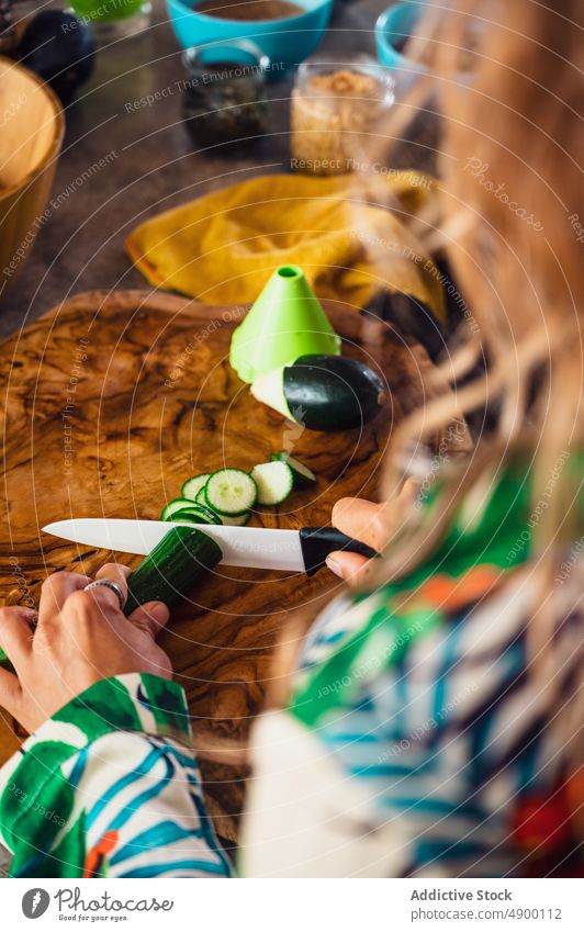 Faceless woman cutting cucumber for salad cook vegetable vegan kitchen healthy food product culinary housewife tasty cutting board nutrient process