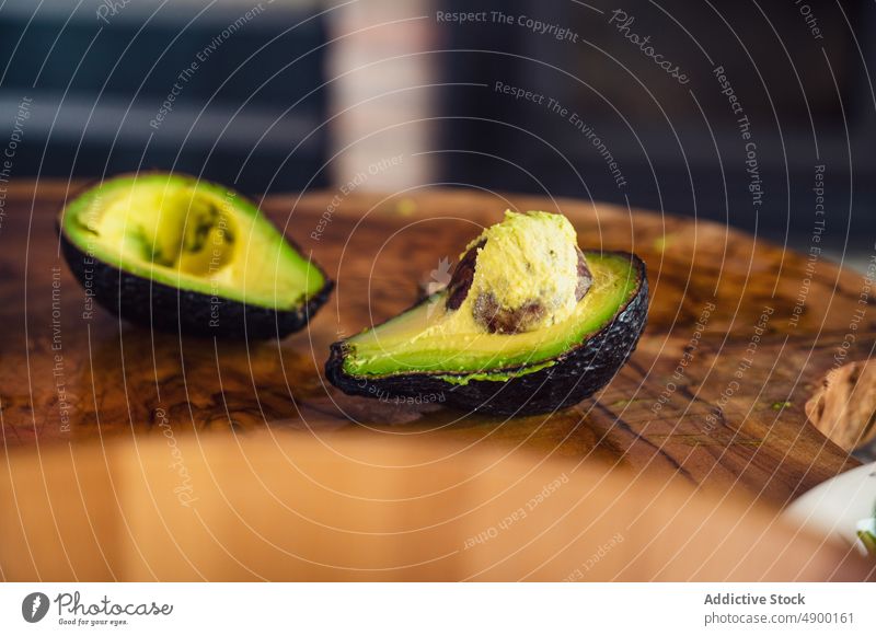 Halved avocado on lumber slab half fresh wooden kitchen healthy food diet seed ripe ingredient home organic vitamin vegan prepare raw natural product vegetarian