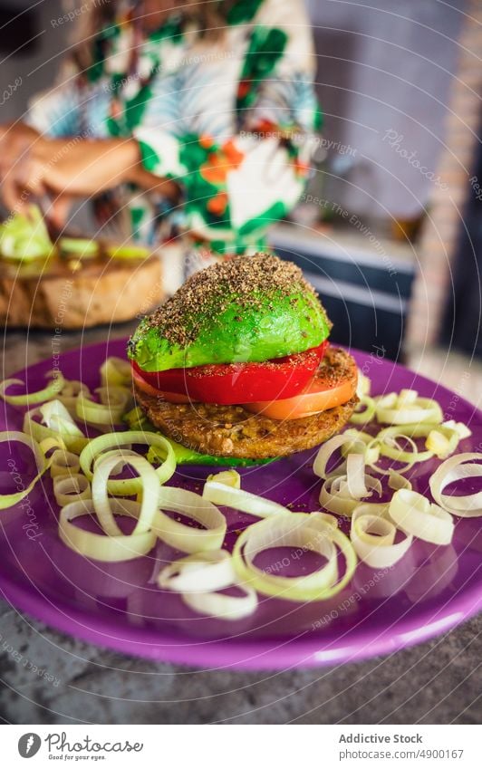 Fresh vegan burger on plate avocado vegetable patty pepper tomato onion lunch kitchen cook healthy food vegetarian vitamin organic fresh dish portion culinary