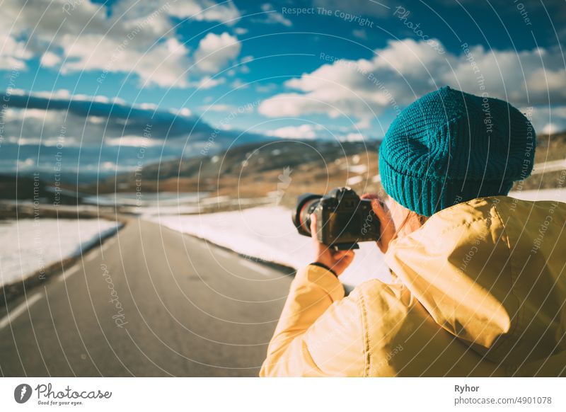 Aurlandsfjellet, Norway. Young Happy Woman Tourist Traveler Photographer Taking Pictures Photos Of Aurlandsfjellet Scenic Route Road. Norwegian Landmark And Popular Destination