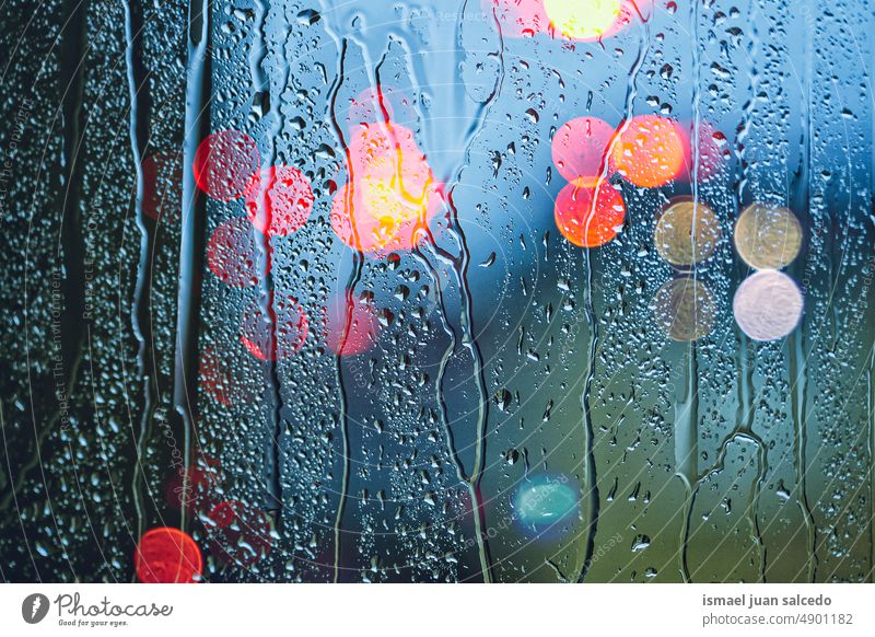 raindrops on the window and street lights background night colors colorful multicolored bokeh circles rainy rainy days water glass bright shiny blur blurred