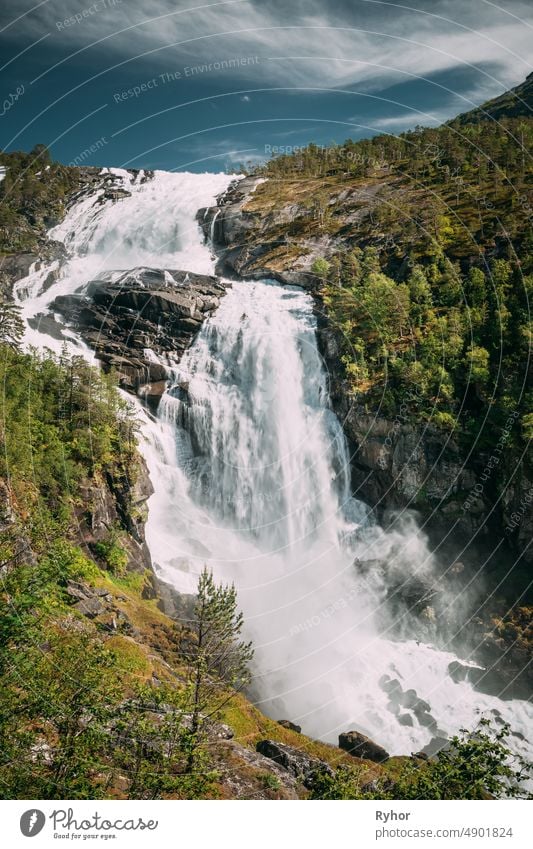 Kinsarvik, Hordaland, Norway. Waterfall Nyastolfossen In Hardangervidda Mountain Plateau. Nyastolsfossen in Spring Sunny Day. Height Of 115 m. Norwegian Landmark And Popular Destination.