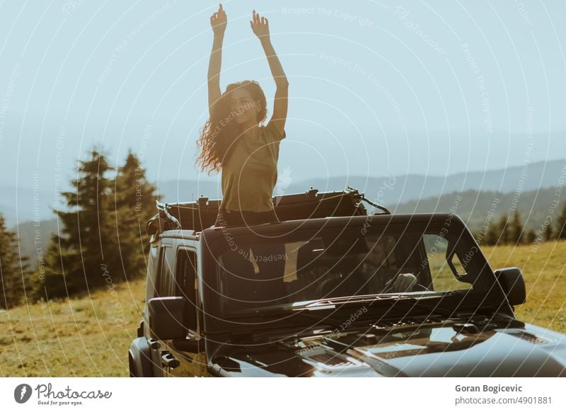 Young woman enjoying freedom in terrain vehicle on a sunny day happy smile beautiful road female drive young car happiness fun auto trip journey transport