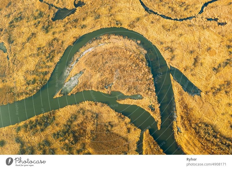 Aerial View Of Dry Grass And Partly Frozen River Landscape In Late Autumn Day. High Attitude View. Marsh Bog. Drone View. Bird's Eye View aerial aerial view