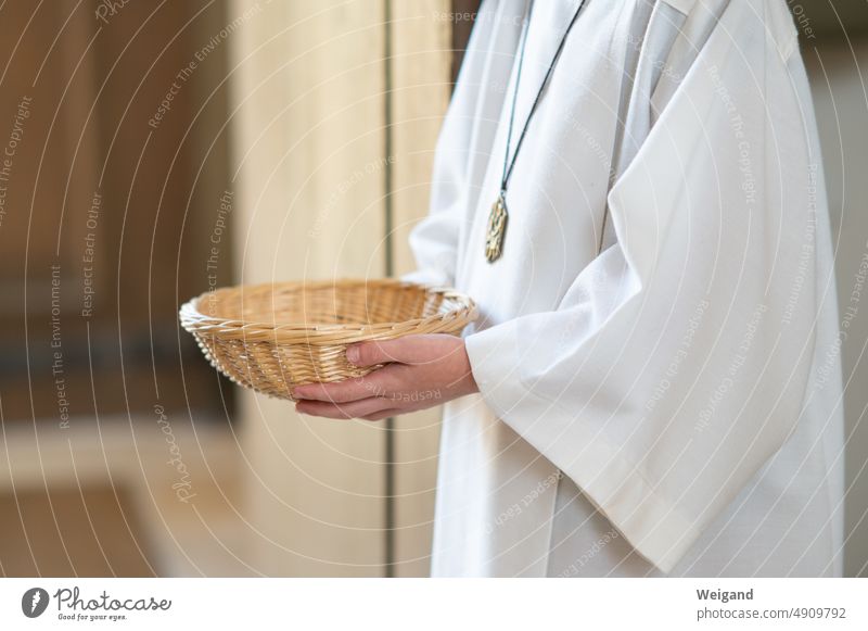 Altar server with basket in church service liturgy Church service Catholic Belief altar boy Ministrant celebrate God bell bag Money tax Church tax