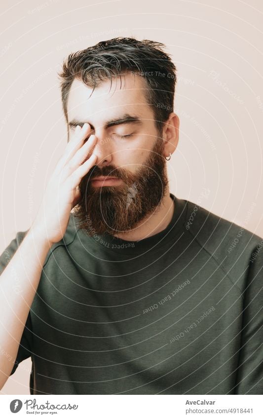 Young man having a mental breakdown,experiencing mental anguish. Covering face with hands thinking worried about his future. Mental health, self help concept, Ask for help, talk to someone. Psychology