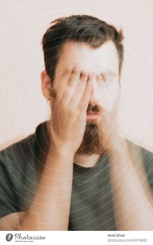 Young man having a mental breakdown,experiencing mental anguish. Covering face with hands thinking worried about his future. Mental health, self help concept, Ask for help, talk to someone. Psychology