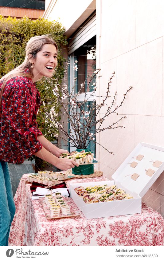 Content woman serving tortilla rolls on table serve snack food appetizer terrace banquet dish tasty delicious appetizing tableware glad delight house lunch