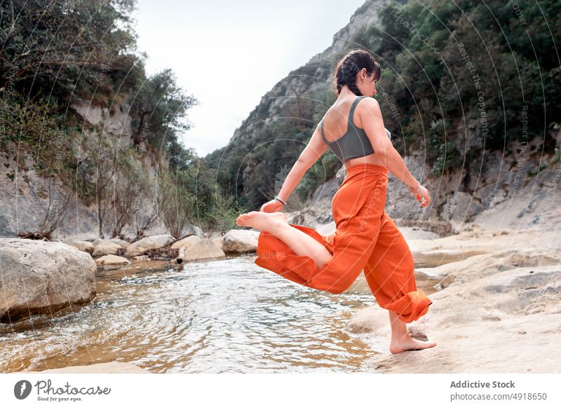 Young woman having fun in the river forest vacation lifestyle nature travel young jumping stones outdoor people leisure activity adventure lake hike holiday