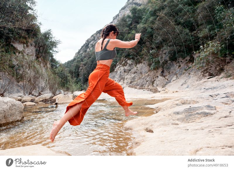 Young woman having fun in the river forest vacation lifestyle nature travel young jumping stones outdoor people leisure activity adventure lake hike holiday