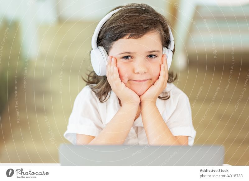 Girl with a bored face sitting in front of a laptop girl young home computer student education annoyed headphones learning beautiful browsing studying online