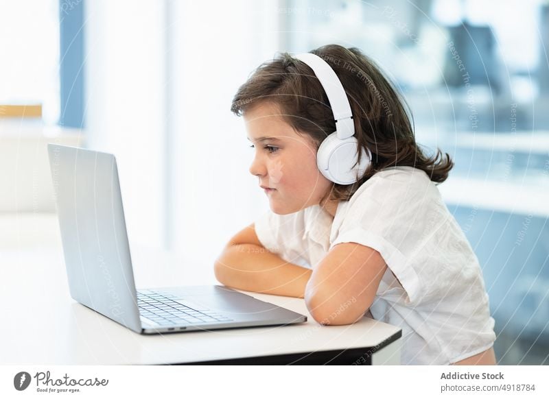 Girl sitting in front of a laptop girl young home computer student education headphones learning focus beautiful browsing studying online internet person