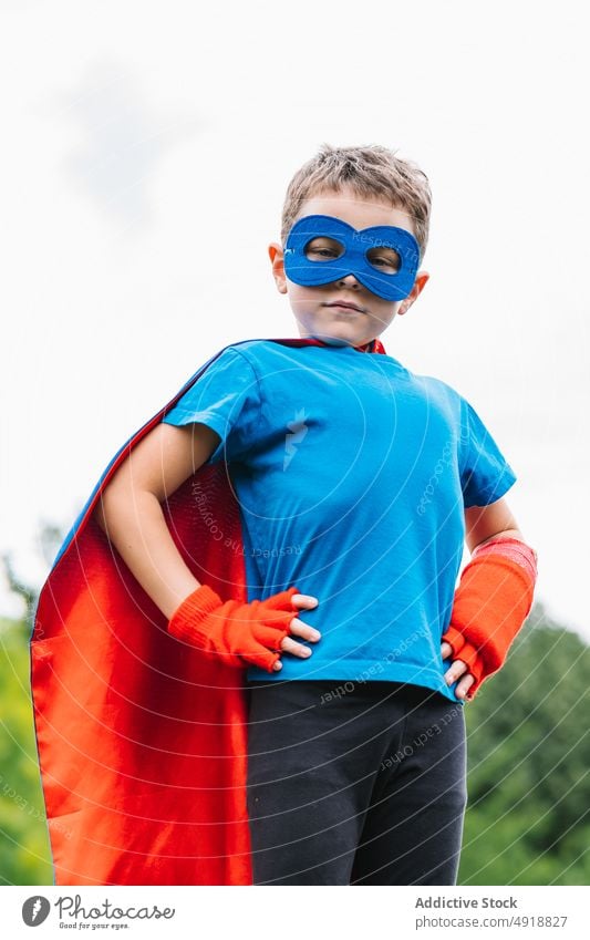 Little superhero with flying cape boy brave summer park pretend play weekend costume sky gray kid confident child male childhood trees protect little cloak