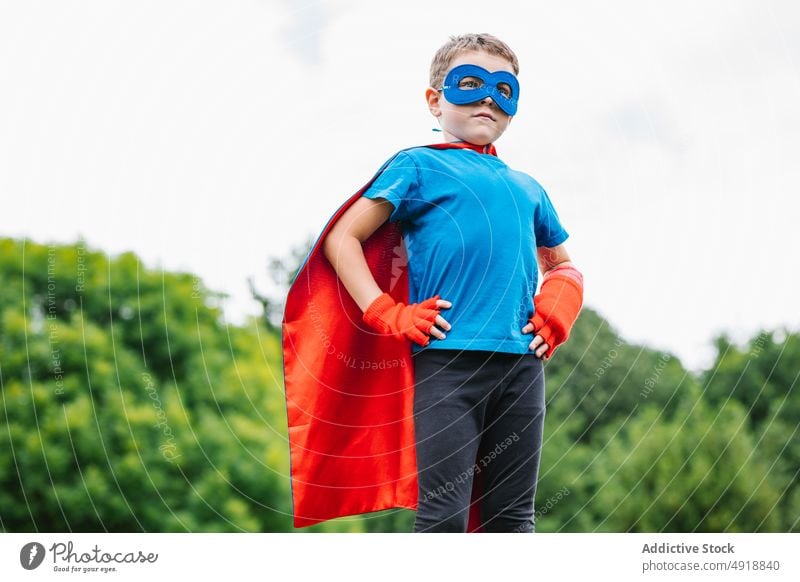 Little superhero with flying cape boy brave summer park pretend play weekend costume sky gray kid confident child male childhood trees protect little cloak