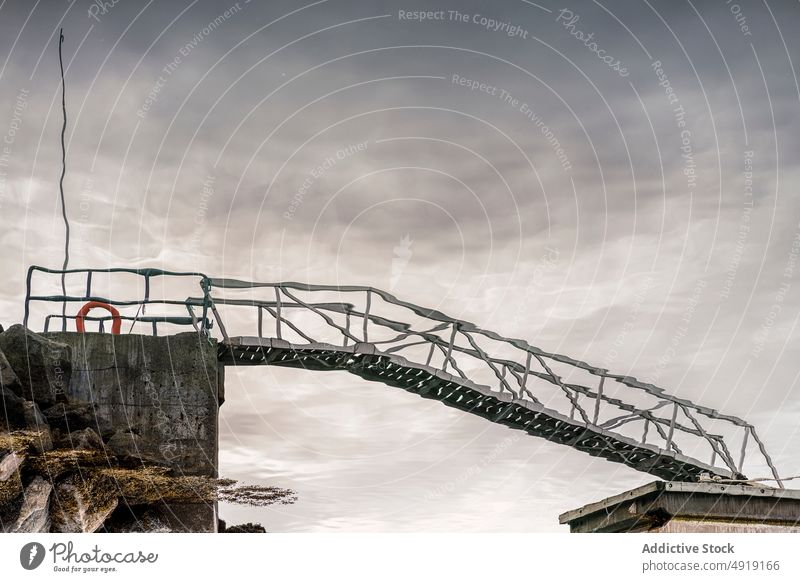 Reflection of gangway in sea water harbor reflection cloudy sky lifebuoy storm gray iceland structure construction marine shore metal clean port pier ocean