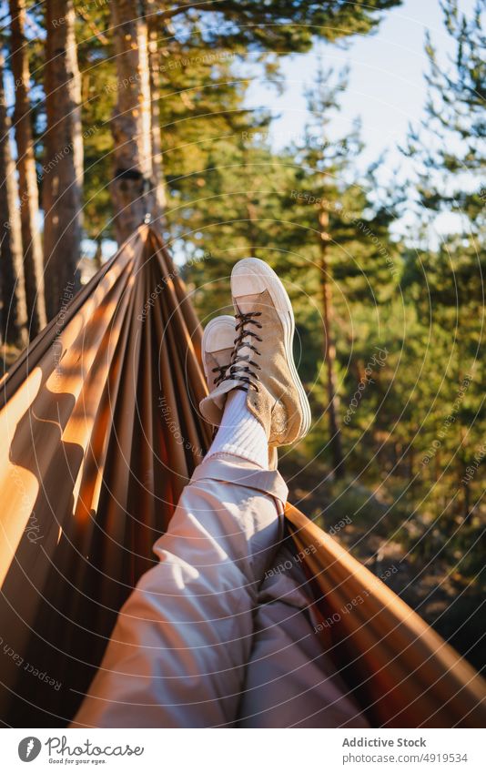 Unrecognizable traveler lying in hammock forest nature recreation woods leisure chill tourism adventure trip tourist leg pastime tree summer plant sunshine