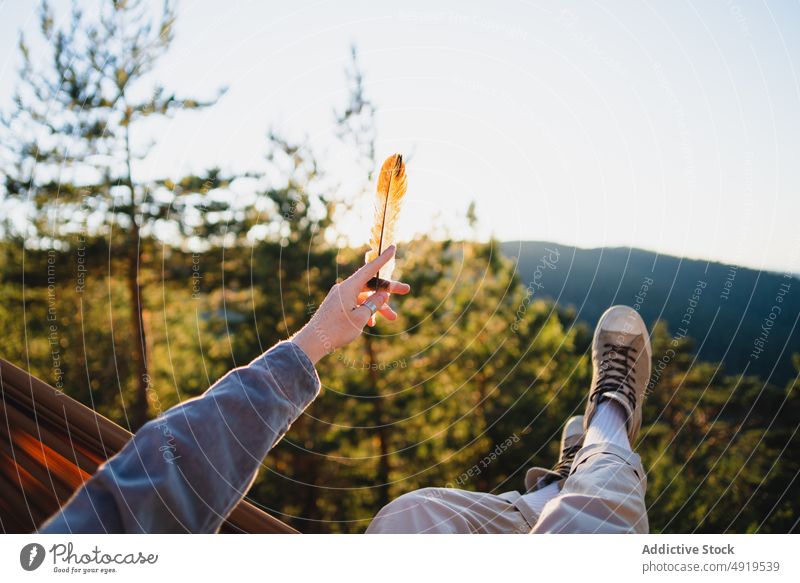 Faceless man resting in hammock in woods feather forest nature recreation leisure chill enjoy countryside trip adventure outstretch pastime headwear tree hat