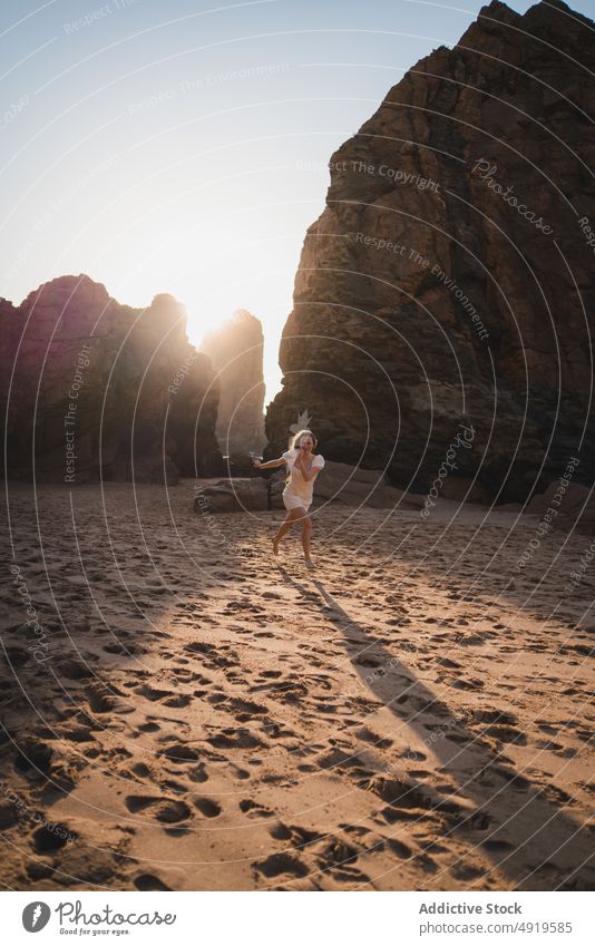 Woman running on shore with cliffs woman traveler sea rock beach water sunset journey sunlight sundown tourist evening pastime leisure adventure active female