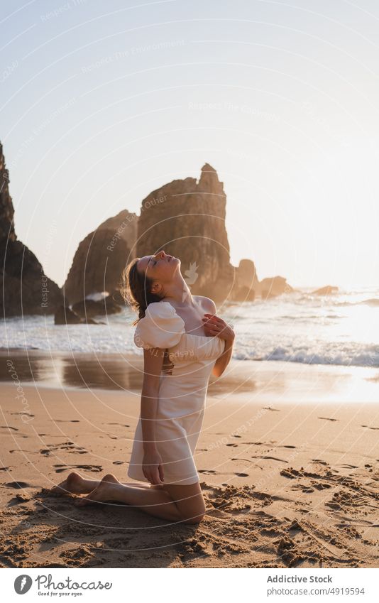 Woman sitting near waving sea woman traveler beach water shore sunset pastime journey trip rest sunlight recreation wave cliff sundown rock tourist evening lady