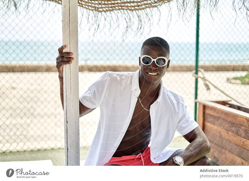 Black man resting on chair recreation relax chill pastime sunglasses black african american ethnic lounger summer confident trendy water summertime calm