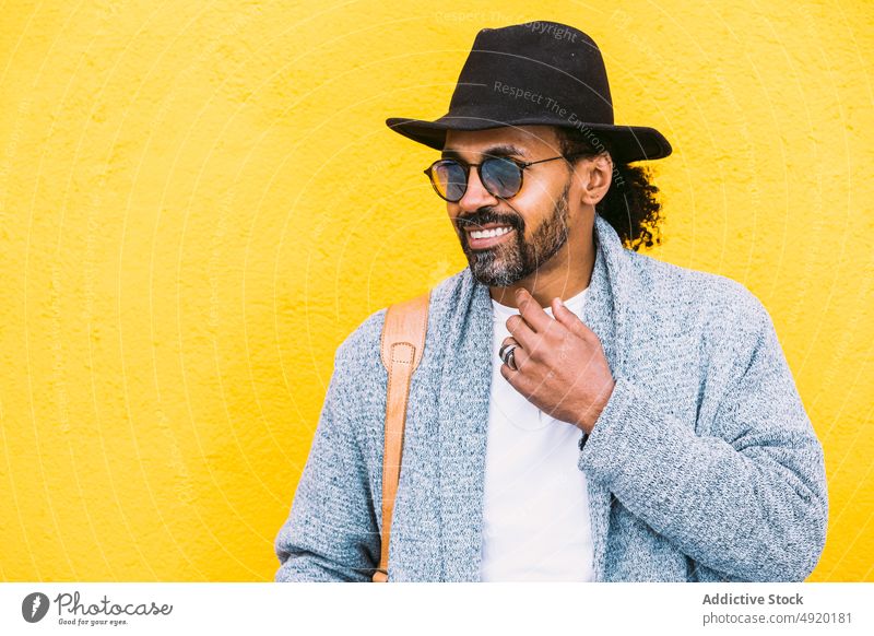 Happy Hispanic man against yellow wall street style happy laugh urban outfit appearance bright color male adult hispanic ethnic bag shoulder cheerful optimist