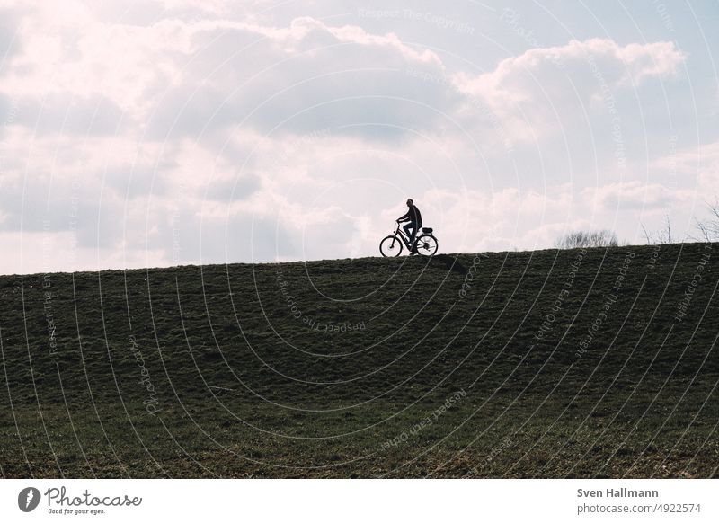 Cyclist on dike cycle Clouds Sky Outdoors Bicycle Cycling Shadow Silhouette Dike cyclists Lifestyle Movement Wheel Sports urban swift Speed Driving