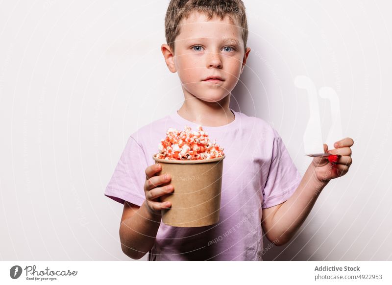 Boy holding 3D glasses and popcorn child 3d boy kid entertain amusement movie cartoon snack interesting hobby shock vision treat imagination delicious tasty