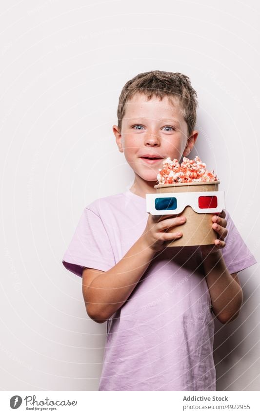 Cheerful boy with 3D glasses and popcorn kid 3d amusement snack movie happy hobby treat food entertain pleasure content glad optimist delicious tasty delight