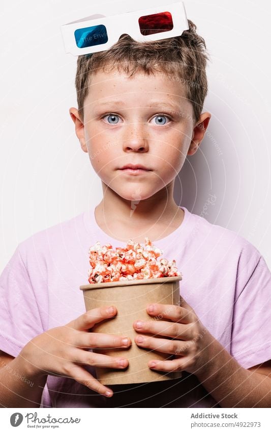 Astonished boy with 3D glasses and popcorn kid 3d snack amusement astonish movie shock treat wow light bucket stare amazed dumbfound hobby cinema food entertain