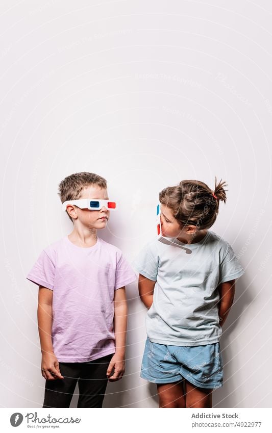 Serious children in 3D glasses 3d sibling vision serious cinema movie together calm hobby kid childhood paper boy girl casual studio optical adorable amusement