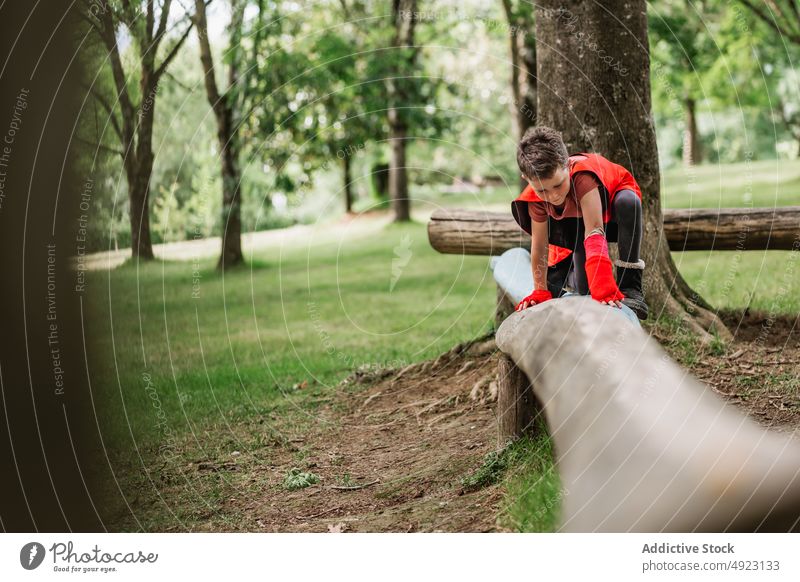 Boy in superhero costume balancing on log boy walk balance forest weekend male summer park cape play child kid adorable cute glove power daytime activity