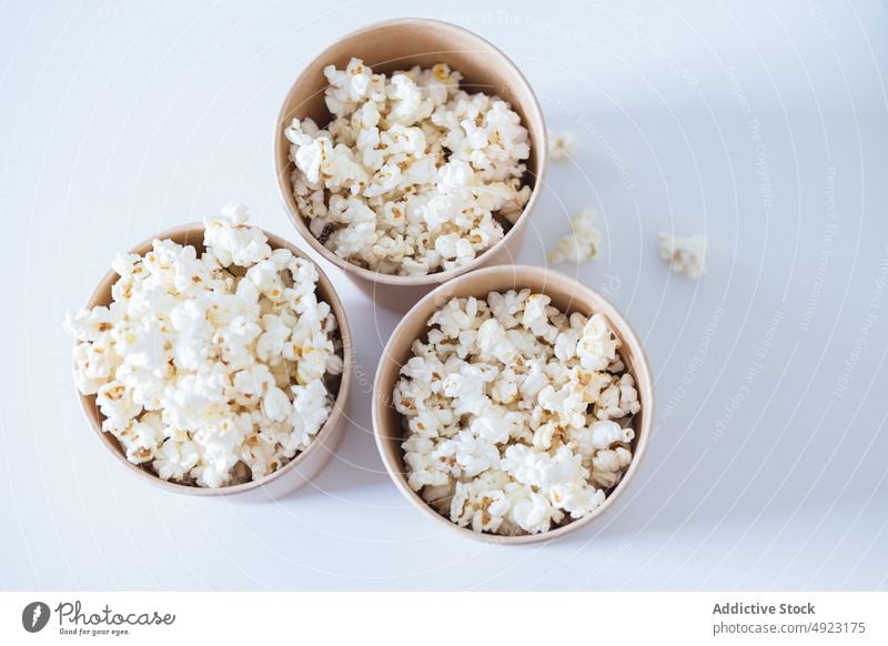 Buckets with popcorn on table bucket snack food pile treat serve heap showtime portion product calorie unhealthy container yummy tasty delicious carton crunch