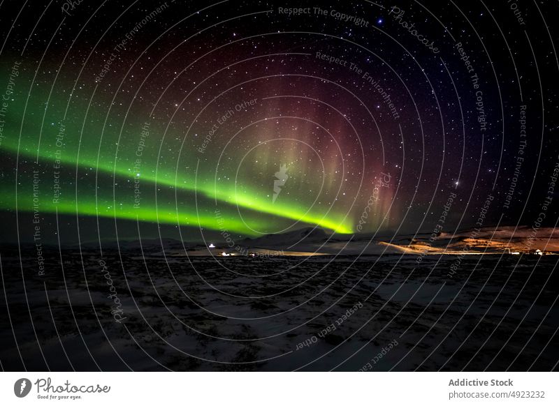 Scenic northern lights at night in mountainous terrain aurora aurora borealis winter sky starry polar iceland snow majestic nature rock rocky peak illuminate