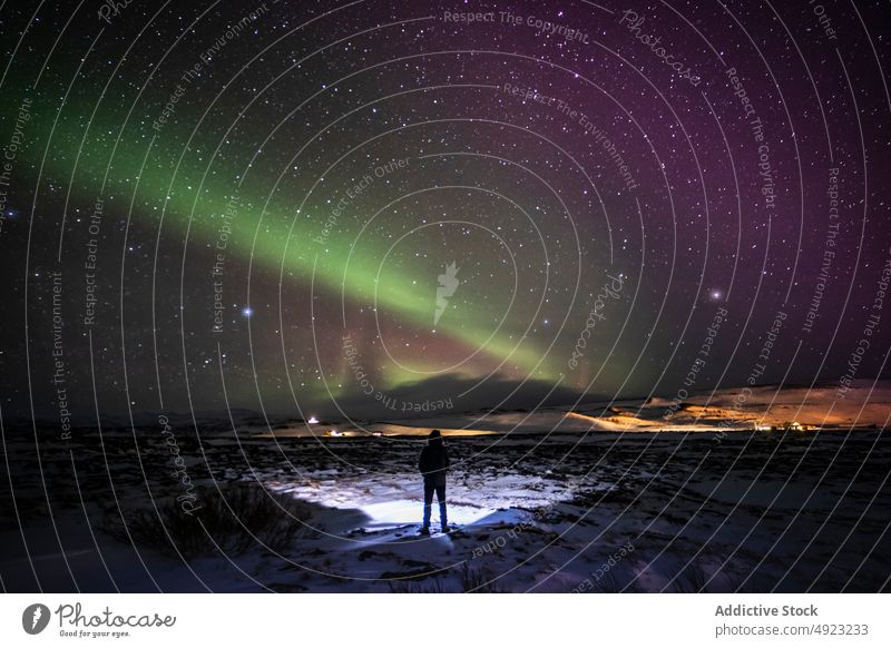 Traveler admiring aurora borealis in night sky northern light terrain traveler admire snow iceland starry green glow cold polar nature astronomy tourism winter