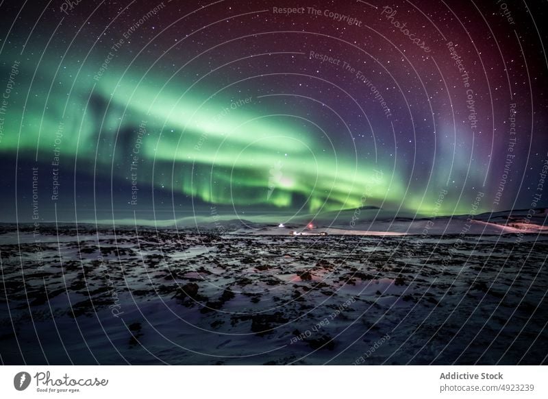 Scenic northern lights at night in mountainous terrain aurora aurora borealis winter sky starry polar iceland snow majestic nature rock rocky peak illuminate