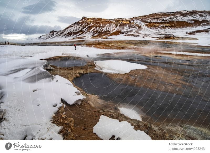 Anonymous people standing in geothermal valley in mountains traveler area spring terrain steam volcanic iceland vapor highland nature lake water hot warm