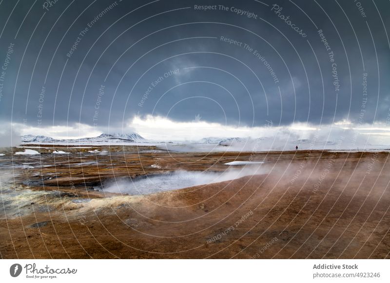 Man standing in geothermal valley in mountains man traveler area spring terrain steam volcanic male iceland vapor highland nature lake water hot warm explore