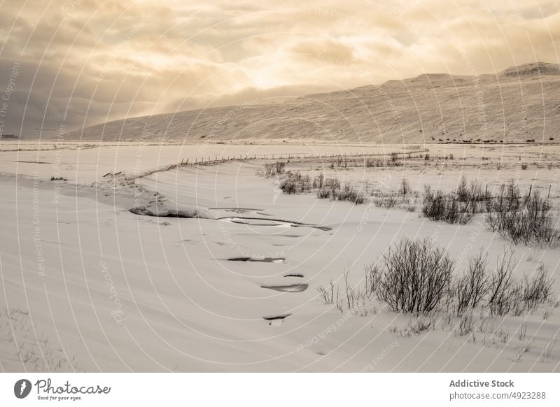 Frozen lake in mountainous terrain in winter snow ice landscape scenery wintertime highland iceland sky tranquil picturesque cloudy idyllic nature breathtaking