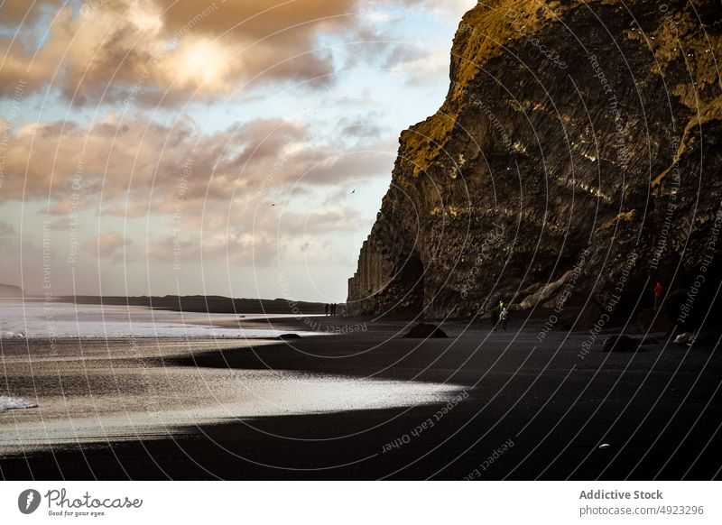 Travelers admiring volcanic black sandy beach landscape formation together sea nature wave storm stone cliff people admire coast ocean shore bay traveler