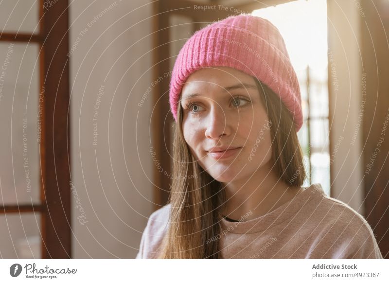 Woman standing near window and looking away woman sunlight appearance hat peaceful dreamy portrait tranquil serene style room feminine wistful sunshine female