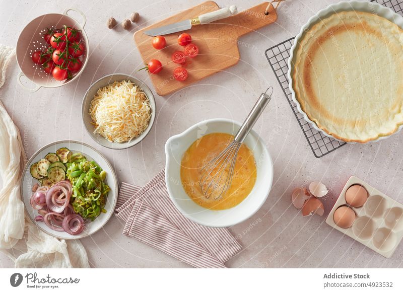 Quiche ingredients and case on table quiche crust kitchen recipe cook fresh composition assorted culinary home food egg bowl whisk cheese vegetable onion