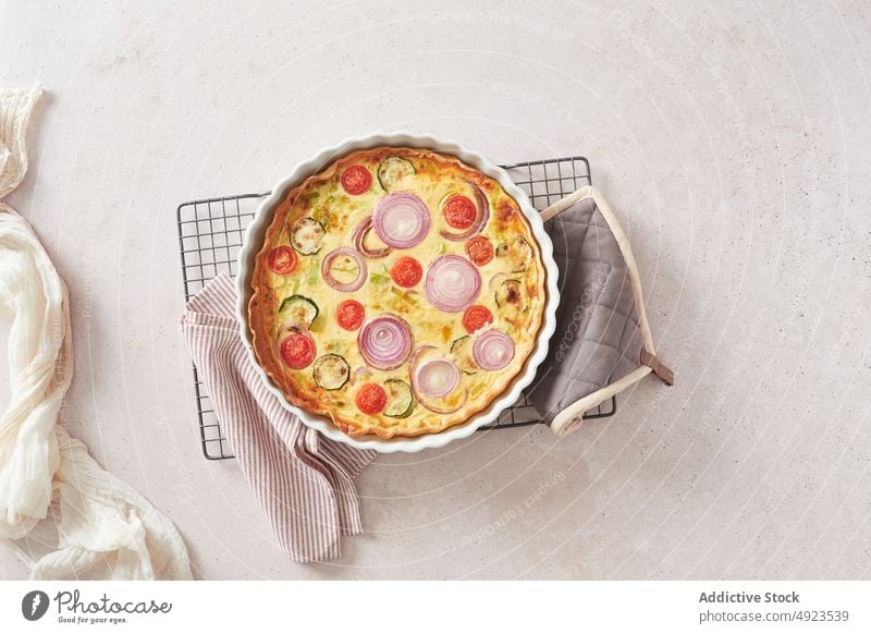 Vegetable quiche on kitchen table vegetable dish napkin grating lunch baking pan food cuisine homemade crust cook fresh zucchini onion tomato baked vegetarian