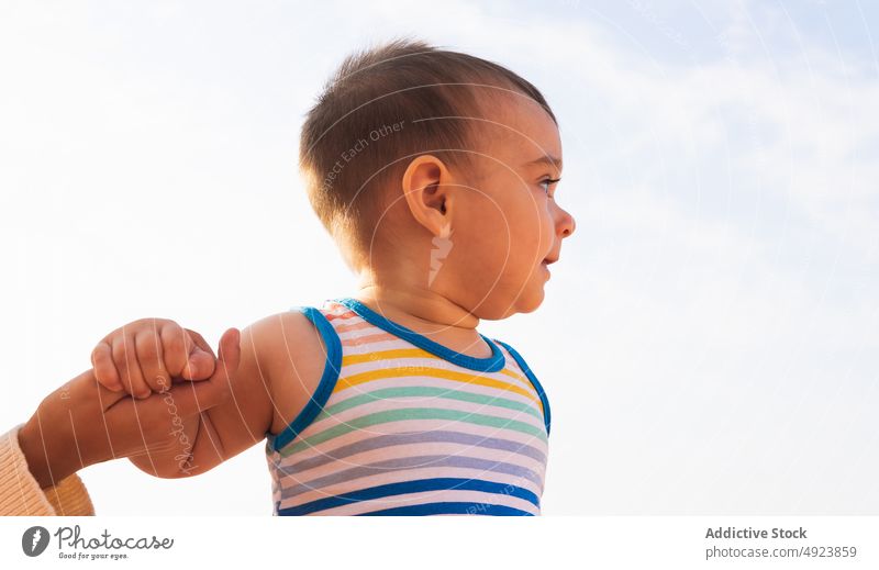 Son holding hand of mom son mother holding hands support cloudy blue sky summer weekend together cute toddler daytime casual tank top stripe tender season child