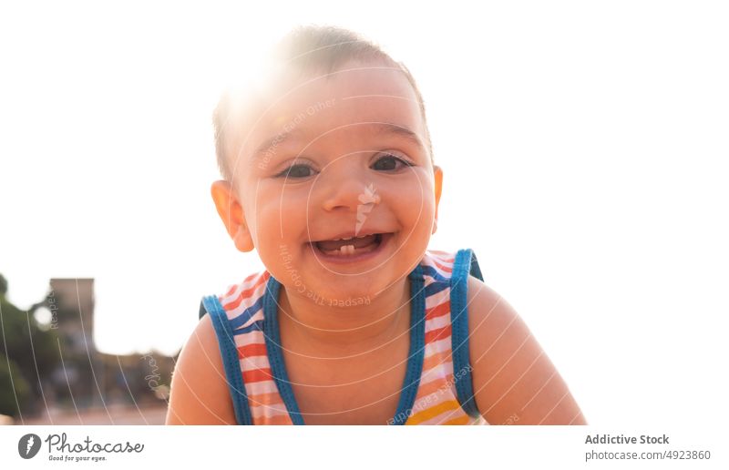 Backlit portrait of a baby son mother cloudy summer weekend cute toddler daytime casual tank top stripe tender season child adorable childhood grasp gentle