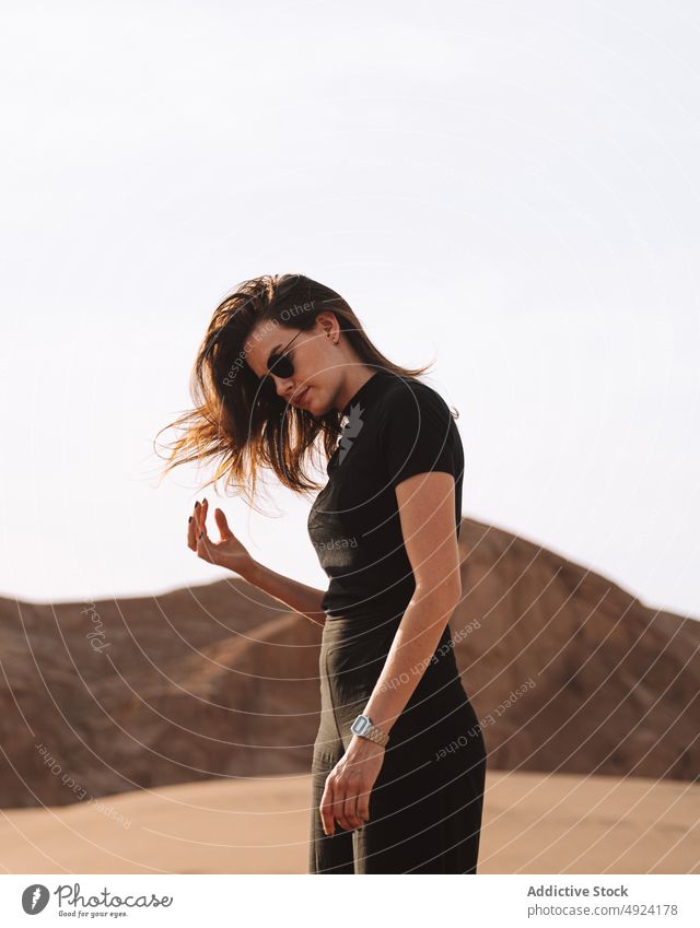 Woman standing near cliff in desert area woman nature trip travel adventure journey pastime rock sunglasses shadow tourist feminine stone enjoy light rocky