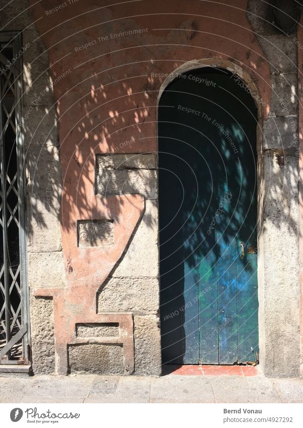 Old door with sculptural facade in the sunshine Mediterranean sea Spain vacation Drop shadow Sun Sunlight Blue Brown Summer coast Vacation & Travel