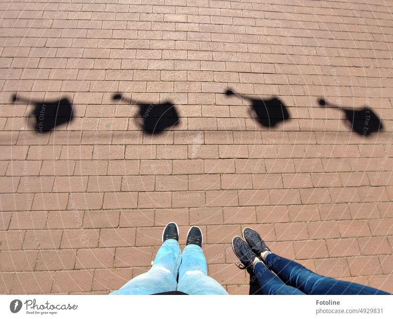 There the two stand and marvel at the shadows of the watering cans on the paving stones. Paving stone Stone Shadow Light Exterior shot Day Colour photo