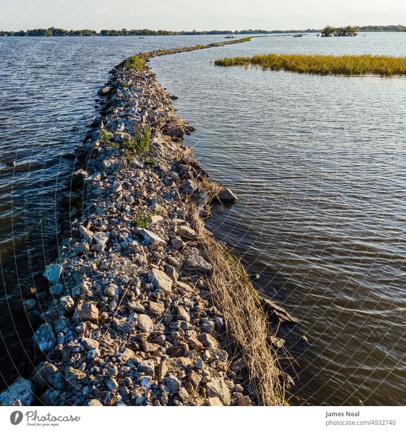 Breakwall with birds during summer on Lake Butte des Morts in Oshkosh Wisconsin lakeshore sunny fox river jagged nature water day background drone midwest usa